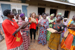 Dr Rasha Kelej in Uganda, holding a chicken gifted to her by the women.jpg